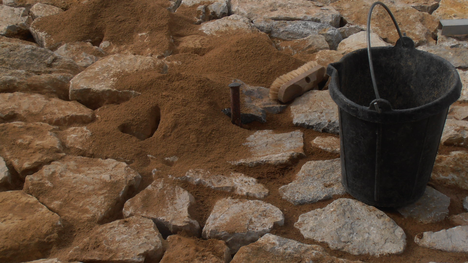 rejuntant amb argila i compactant amb tascó